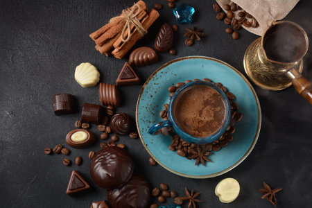 Coffee cup, beans, chocolate on old kitchen table Assortment of dark, white and milk chocolate...