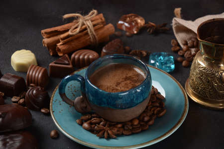 Coffee cup, beans, chocolate on old kitchen table Assortment of dark, white and milk chocolate...
