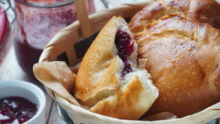 Cherry Pies stuffed with berries cherry, bowl with cherry jam. Homemade sweet pies from yeast dough freshly  baked in ovenの写真素材