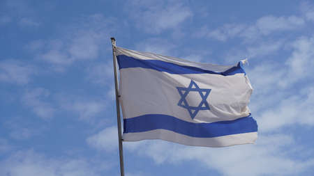 Israeli flag weaving in the wind against bright skies