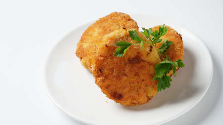 Plate with chicken cutlets. Fried juicy  cutlets on a white plate garnished with parsleyの写真素材