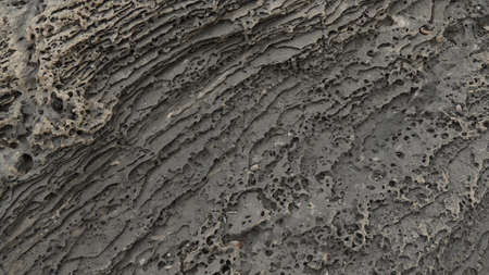 Volcanogenic rock slabs on the seashore. Natural rocky breakwater at seashoreの写真素材