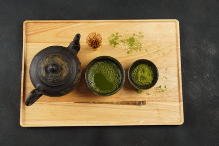 Green matcha tea powder with a bamboo whisk and scoop as used in a traditional Japanese tea ceremonyの写真素材