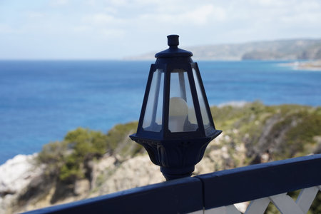Light lantern along the cozy veranda and  turquoise colored bay of Mediterranean sea Rhodes island, Greeceの写真素材