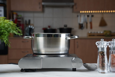 Steel cooking pan without lid on electric hob with boiling waterの写真素材