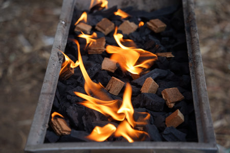 Empty barbecue flaming grill close up with bright flames and  firelighters burningの写真素材