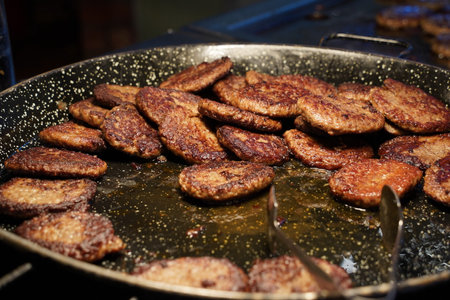 Beef burger patties sizzling on a hot  pan.の写真素材
