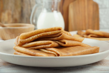 Blini, blintzes, russian crepes stacked on plate over rustic composition background.の写真素材