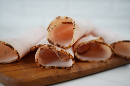 Sliced ham on wooden cutting board. Fresh prosciutto. Pork ham slicedの写真素材