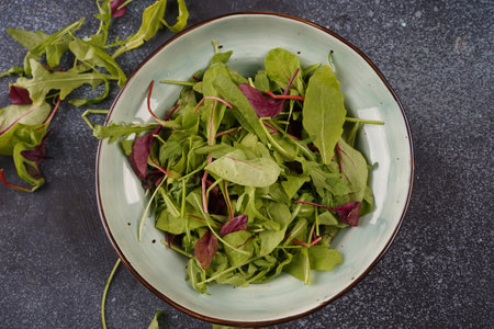 Healthy salad leaves mix in a  over dark  stone or concrete backgroundの写真素材