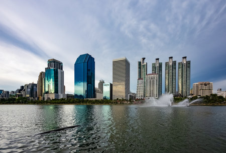 View of Ratchada Lake at cloudy afternoon in Benchakitti Park. Bangkok cityscape at Benjakitti Park.
