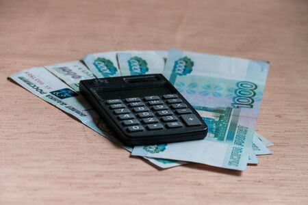 Russian rubles and calculator on a brown tableの写真素材