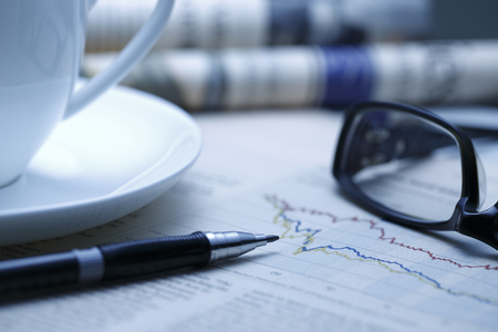 Black pen with financial figures and Glasses,shot with very shallow depth of field. blue tone,の写真素材