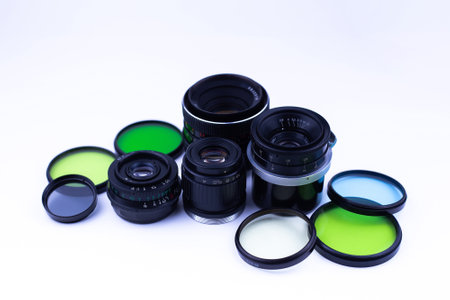 A set of old-vintage lenses and color photo filters on a white backgroundの写真素材