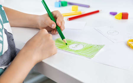 A little kid enthusiastically draws toy money with colored pencils for the game. family budget. economy. money. The kid draws. economic crisis. Kids play.の写真素材