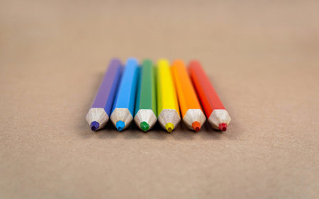 Colored pencils on a brown paper texture background.の写真素材