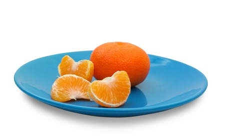 Mandarin and tangerine slices on a blue plate isolated on white backgroundの写真素材