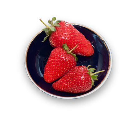 Three ripe strawberries on blue saucer isolated on white backgroundの写真素材