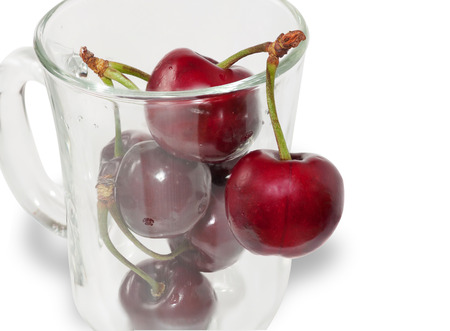 Bunch of cherries in clear glass isolated on white backgroundの写真素材