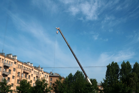 Construction crane on background of surrounding old houses and blue skyの写真素材