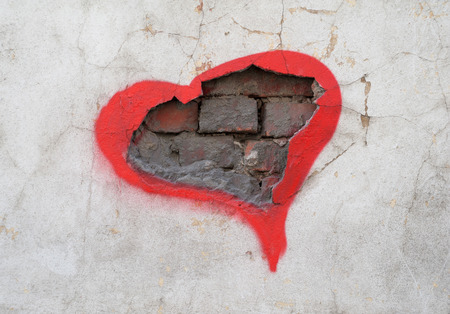 Texture of old wall with hole in which the bricks are visible, encircled in red ink in form of heartの写真素材