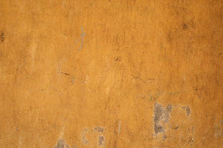 Texture of old rustic wall covered with yellow stuccoの写真素材