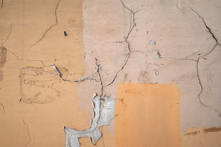 Texture of old rustic wall covered with yellow and pink stuccoの写真素材