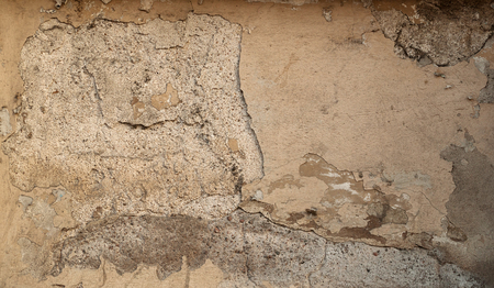 Texture of old rustic wall covered with yellow stuccoの写真素材