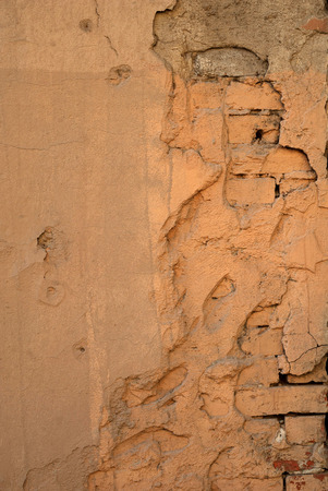 Texture of old rustic wall covered with yellow stuccoの写真素材