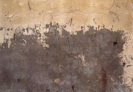 Texture of old rustic wall covered with yellow stuccoの写真素材