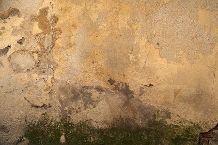 Texture of old rustic wall covered with yellow stuccoの写真素材