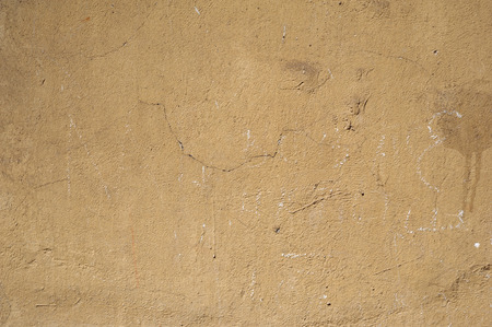 Texture of old rustic wall covered with yellow stuccoの写真素材