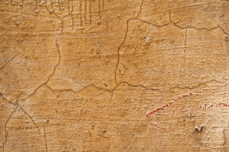 Texture of old rustic wall covered with yellow stuccoの写真素材
