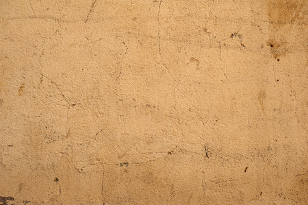Texture of old rustic wall covered with yellow stuccoの写真素材