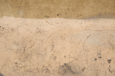 Texture of old rustic wall covered with yellow stuccoの写真素材