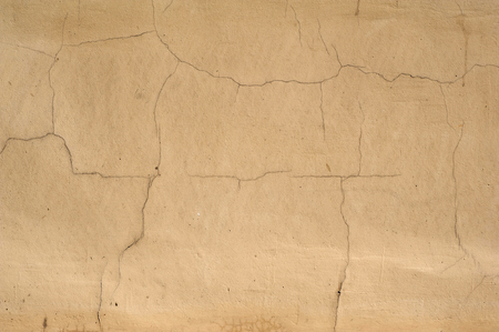 Texture of old rustic wall covered with yellow stuccoの写真素材