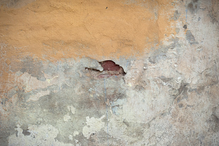 Texture of old rustic wall covered with yellow stuccoの写真素材