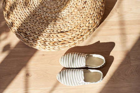 textile moccasins made of natural fabric against the background of a wicker rattan ottoman. Flatlayの写真素材