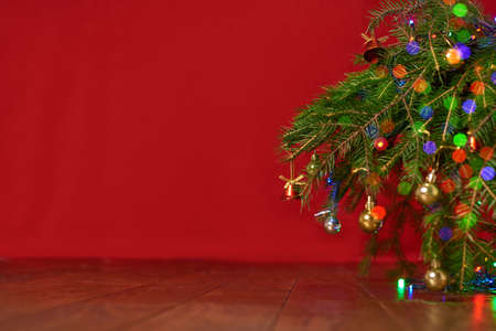 red background, christmas tree, spruce branches with New Years toys, background for a New Year cardの写真素材