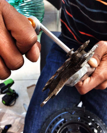 Man fixing bike parts using screwdriver toolの素材