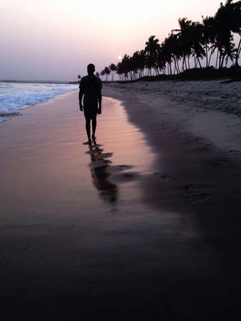 Man walking at sunset on the beach Ghanaの素材