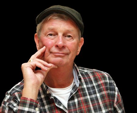 Handsome wise retired gentleman, casually dressed in a pageboy cap and plaid shirt.