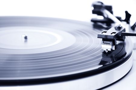 Spinning record player. Focus on the needle head. 