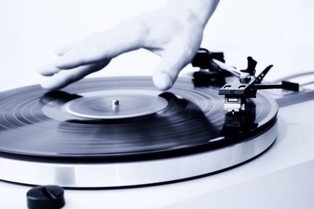 Hand spinning a record, focus on the needle. 