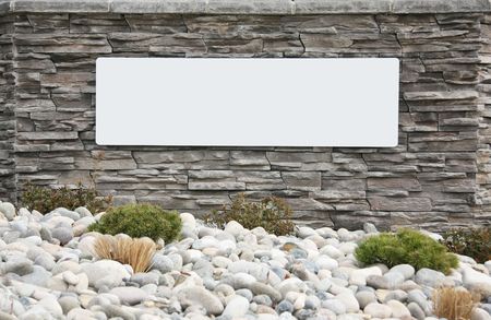 Blank sign on a brick wall at the entrance of a new subdivision. Add your own text. の写真素材