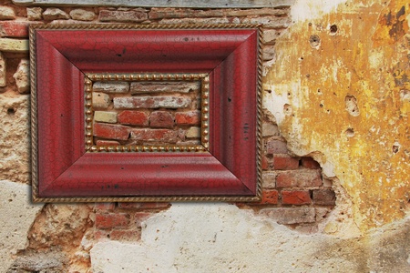 Empty picture frame on an old weathered brick wall with stucco.の写真素材