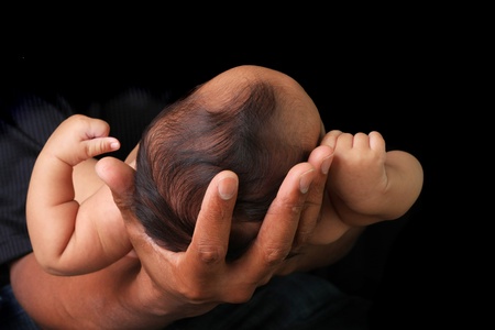Baby girl held in her daddy's hands. の写真素材
