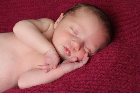 Newborn baby girl asleep on a blanket.の写真素材