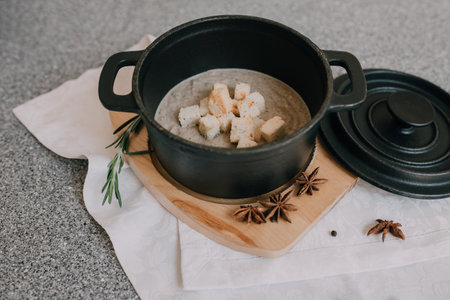 Rice porridge in a pot on a wooden stand on a gray backgroundの写真素材