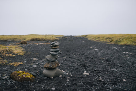 Pile of stones on black volcanic sand in Iceland, selective focusの写真素材